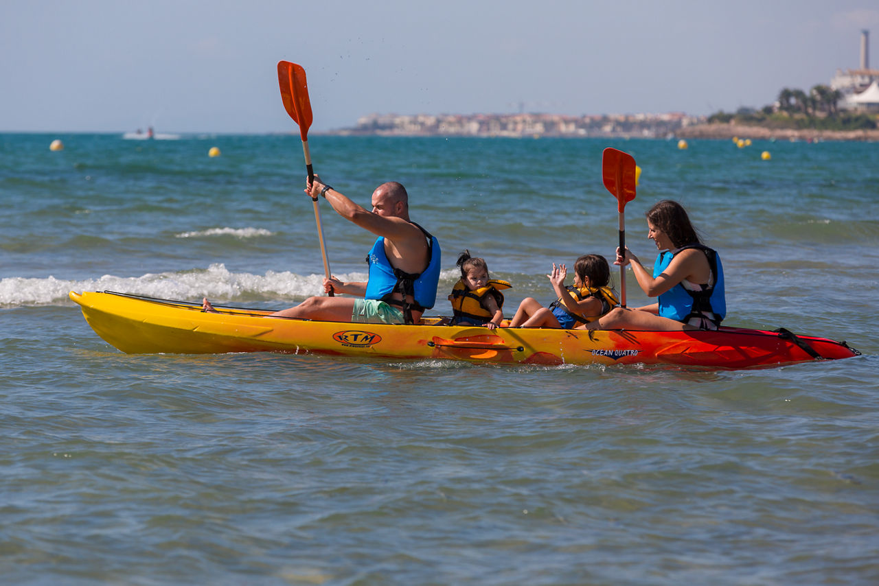 Família practicant caiac, activitat nàutica del centre d'aventura i activitats de mar RocRoi, situat a la platja de Ribes Roges de Vilanova i la Geltrú.