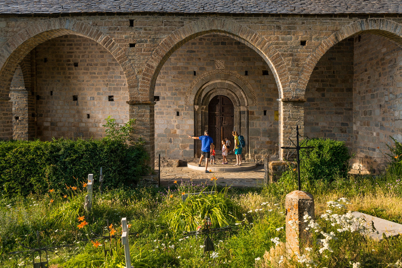 Família amb infants entrant a l'església de la Nativitat de la Mare de Déu de Durro, a la Vall de Boí.