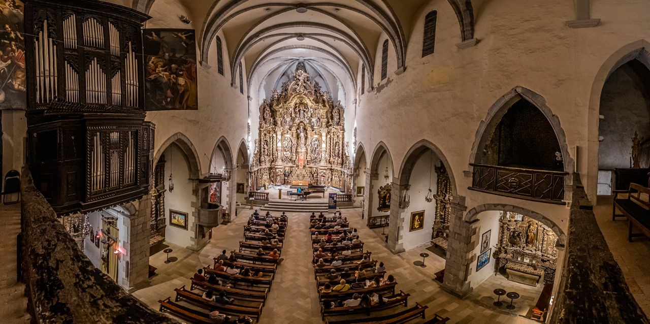Públic assistent a un concert de piano a l'interior de l'església de Santa Maria en el marc del Festival Internacional de Música de Cadaqués.