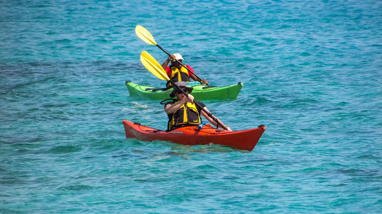 Dues persones remant en caiac per la costa tarragonina, una activitat  de Costa Dorada Experience que inclou la neteja de platges.