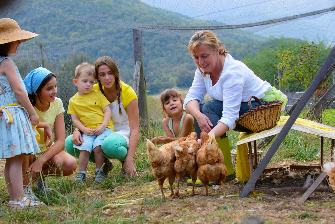 Família en una activitat per alimentar a les gallines de l'allotjament Mas Garganta, a la Garrotxa.
