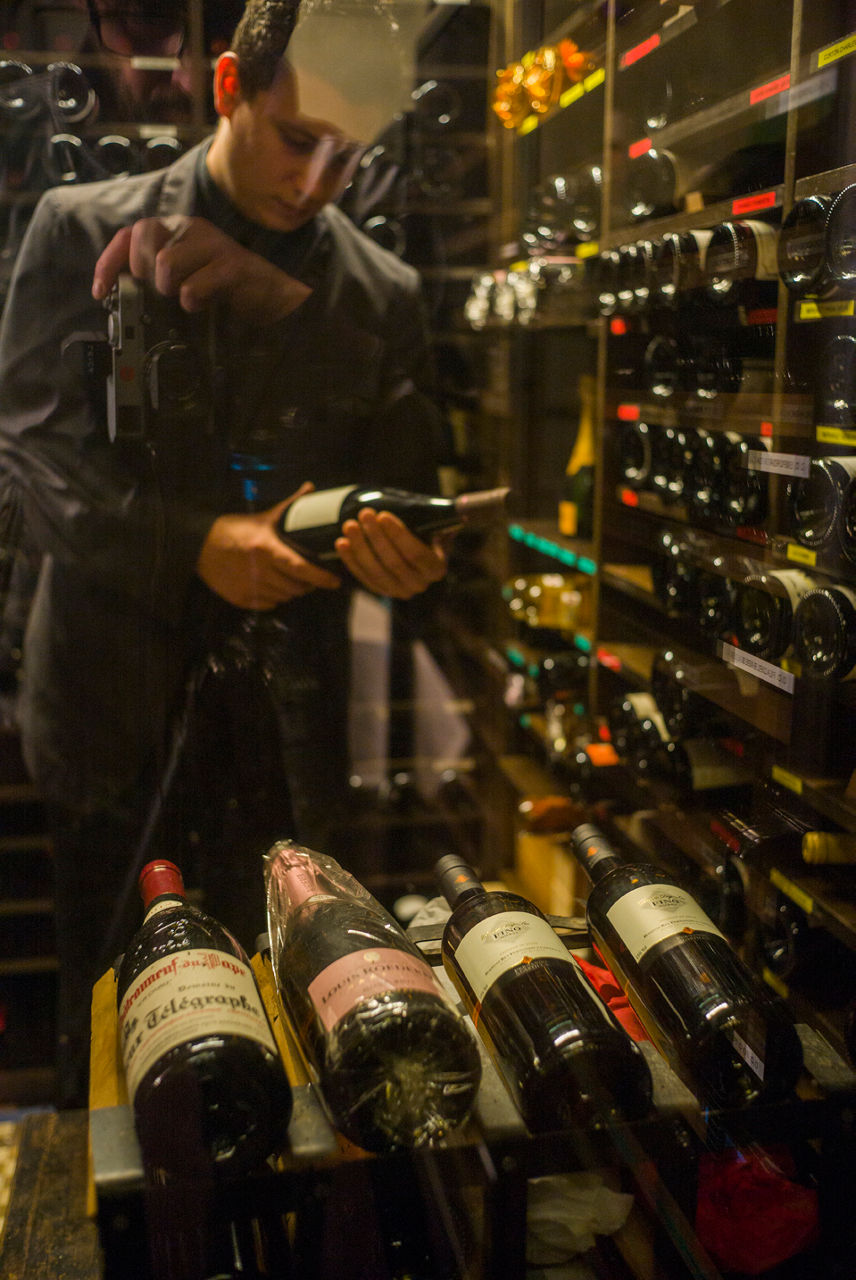 Sommelier escollint una ampolla al celler del Windsor, restaurant als baixos d'una finca modernista de Barcelona.