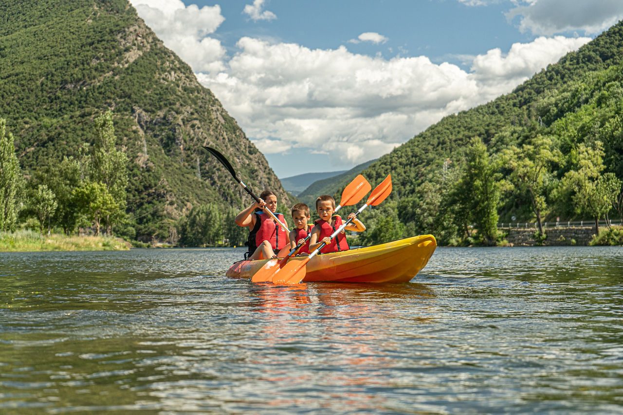 Família navegant en caiac pel llac de la Torrassa, activitat oferta pel centre RocRoi.
