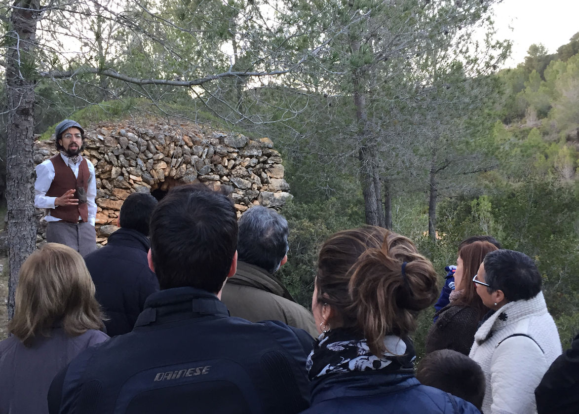 Grup de visitants davant d'una barraca.    