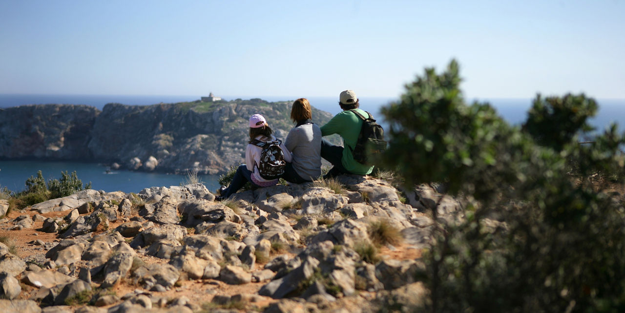 Família mirant cap al mar a Torroella de Montgrí amb el far de la Meda al fons, situat a l'illa de la Meda Gran.