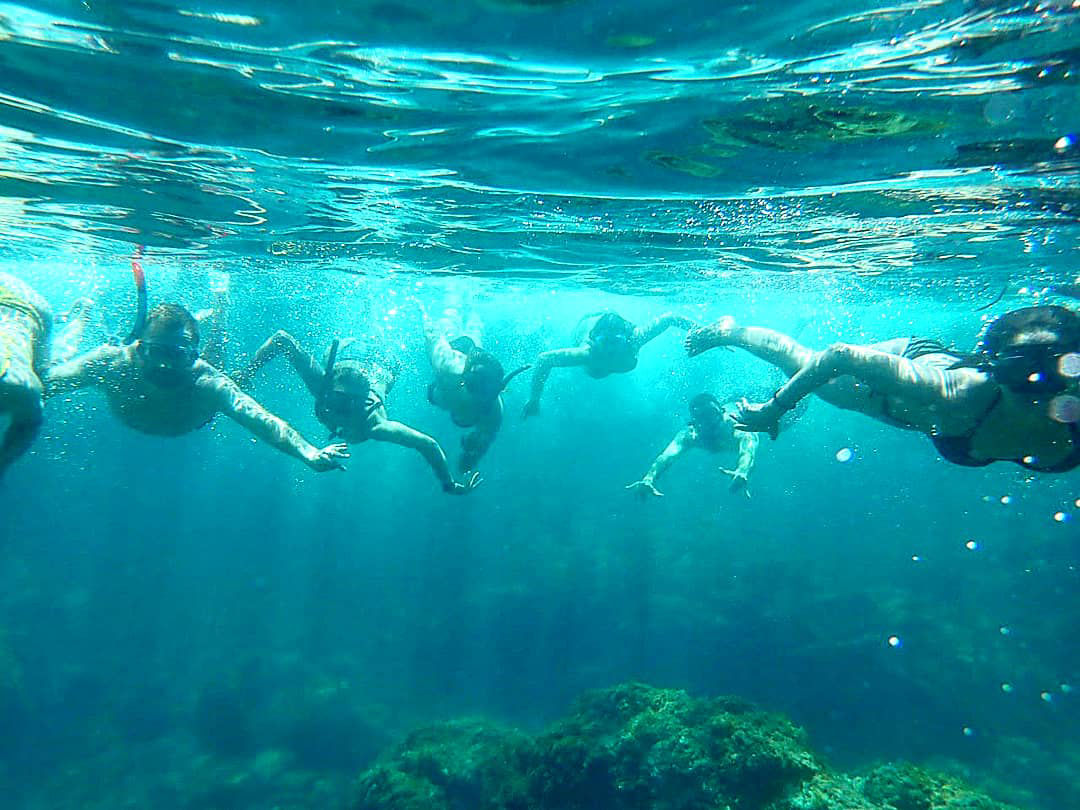Família fent esnòrquel al litoral de Sant Feliu de Guíxols com part de la sortida Kayak + Snorkel de Kayak Center Guíxols.